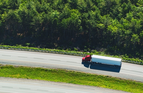 Semi truck drives on a highway in Louisiana on a sunny day