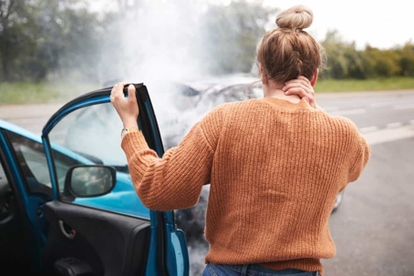 Woman clutches her neck as she gets out of the passenger seat of a car after a car accident